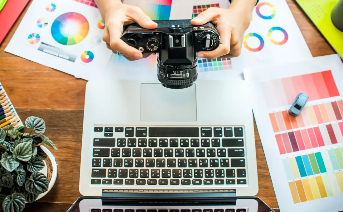 high-angle-view-man-holding-camera-desk-office